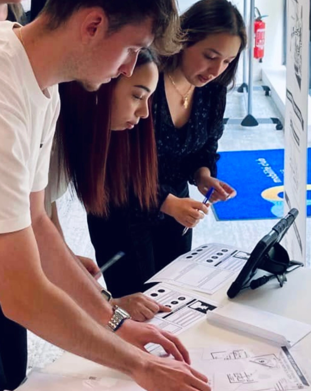 Joueur·euses collaborant autour d’une tablette et de documents papier lors d’un atelier de l’escape game Seconde Chance dédié à la sécurité routière.